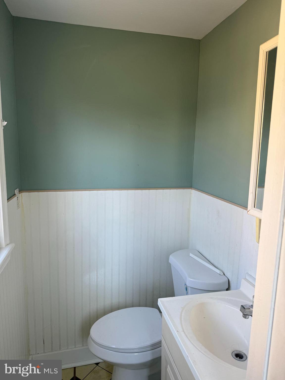 1567 Collings Road Camden, NJ 08104 - Photo 10 of 16 a white toilet sitting next to a white sink and vanity