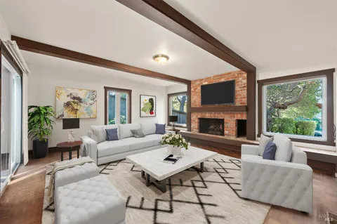 a living room with furniture fireplace and a large window