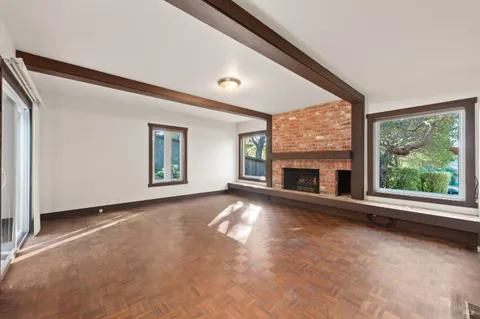 en empty room with windows and fireplace