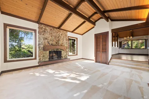 a view of an empty room with a fireplace and a window