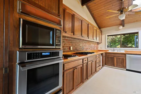 a kitchen with stainless steel appliances granite countertop a refrigerator and wooden cabinets