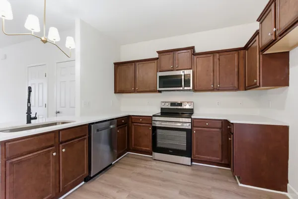 a kitchen with stainless steel appliances granite countertop a sink stove and microwave