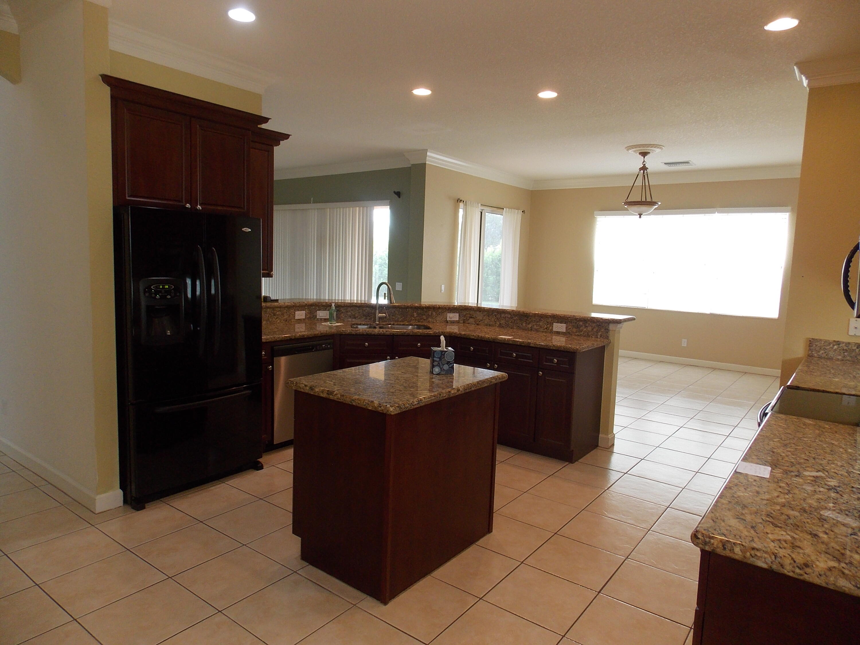323 Northwest Sheffield Circle Port St. Lucie, FL 34983 - Photo 11 of 31 a kitchen with a sink and a refrigerator