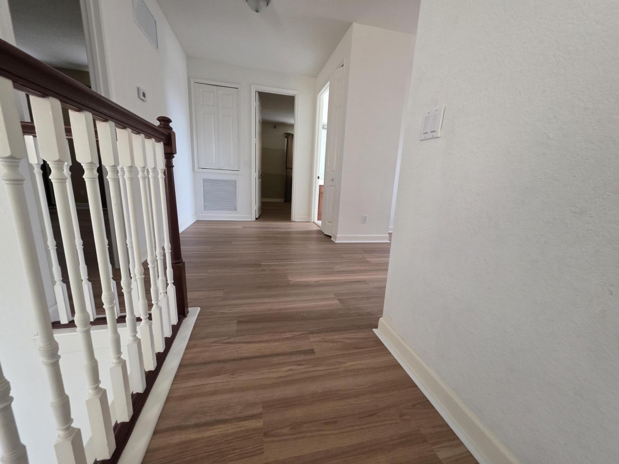 323 Northwest Sheffield Circle Port St. Lucie, FL 34983 - Photo 17 of 31 a view of a hallway with wooden floor and staircase