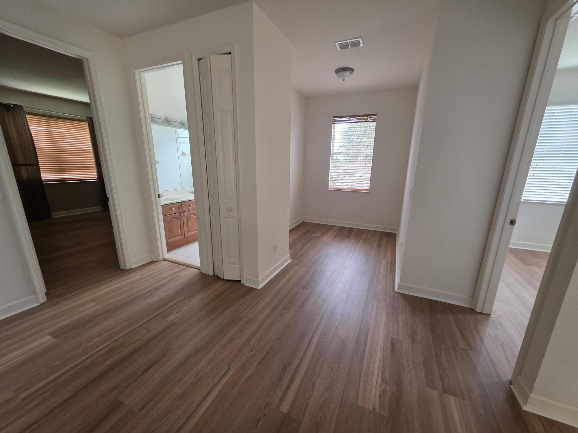 323 Northwest Sheffield Circle Port St. Lucie, FL 34983 - Photo 18 of 31 an empty room with wooden floor and windows