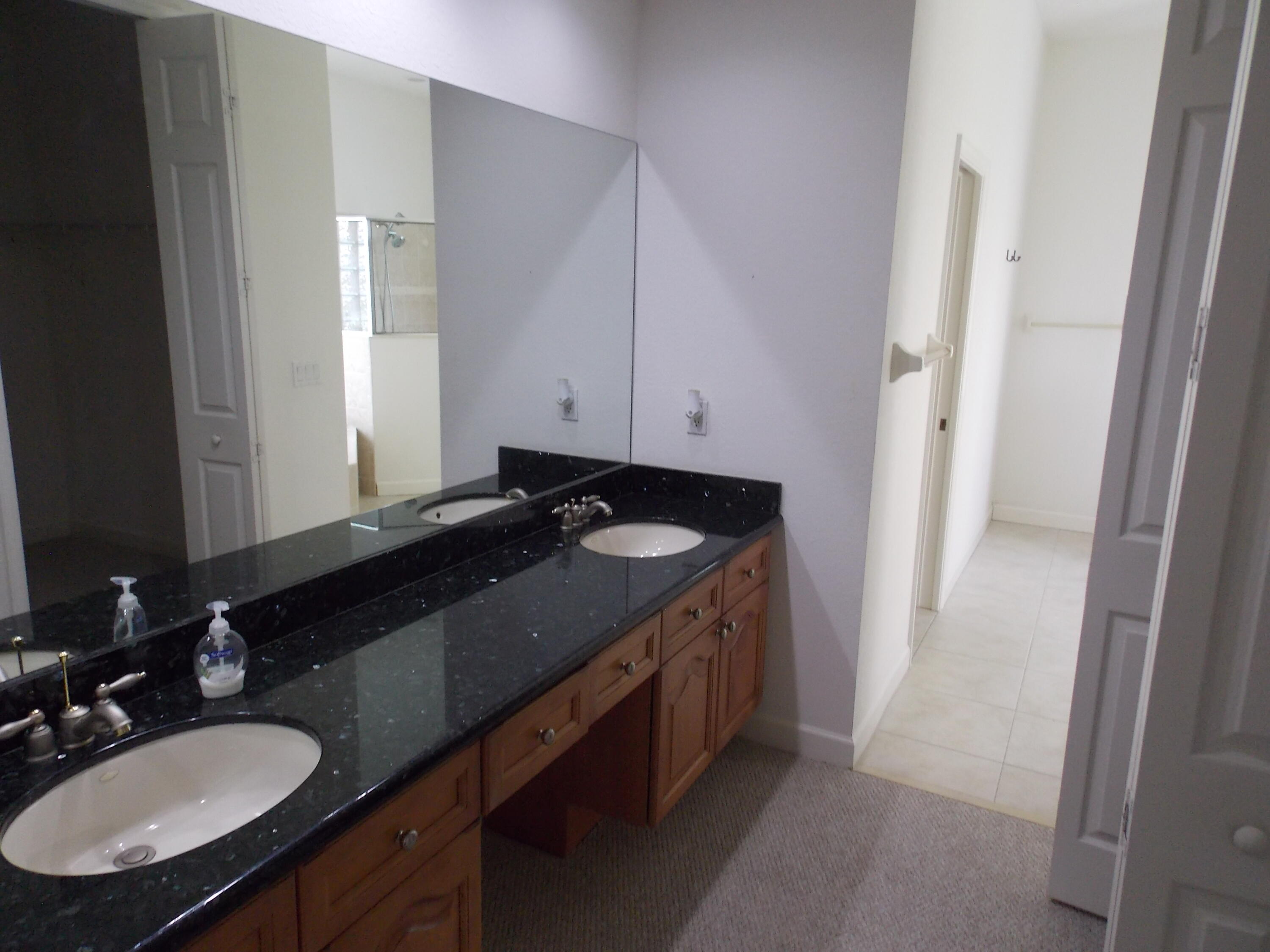 323 Northwest Sheffield Circle Port St. Lucie, FL 34983 - Photo 19 of 31 a bathroom with a granite countertop sink and a mirror