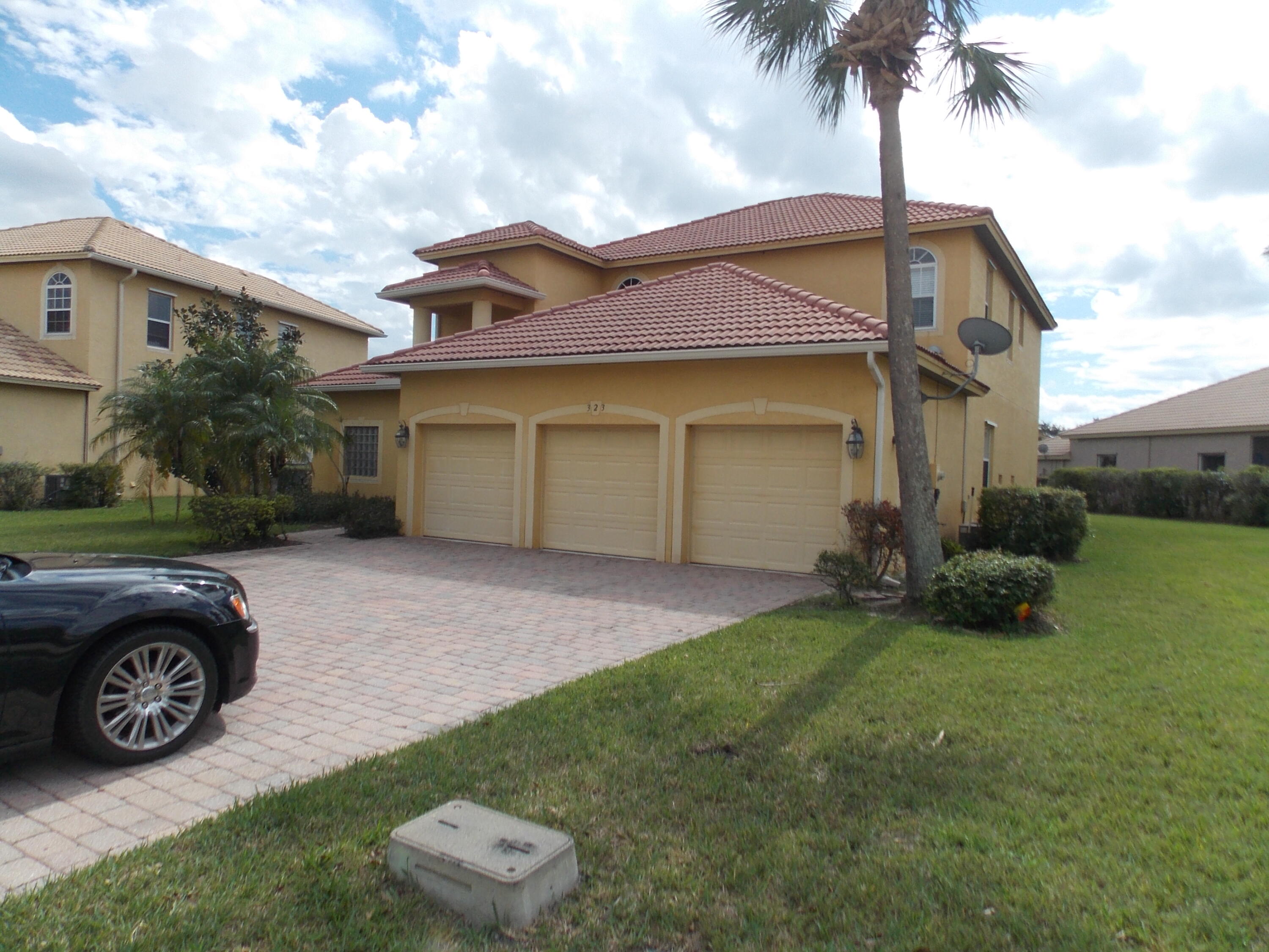 323 Northwest Sheffield Circle Port St. Lucie, FL 34983 - Photo 2 of 31 a front view of a house with a garden and trees