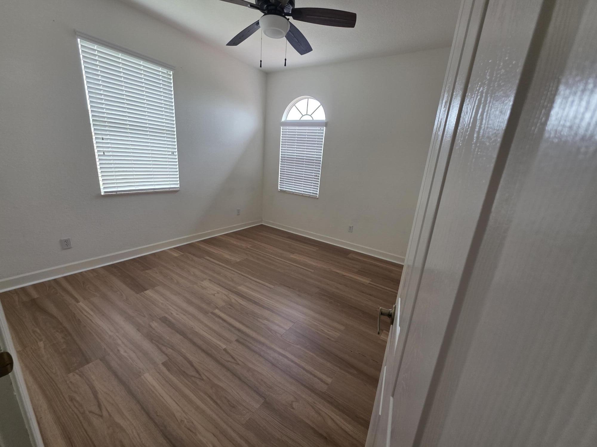 323 Northwest Sheffield Circle Port St. Lucie, FL 34983 - Photo 22 of 31 a view of an empty room with wooden floor and a window