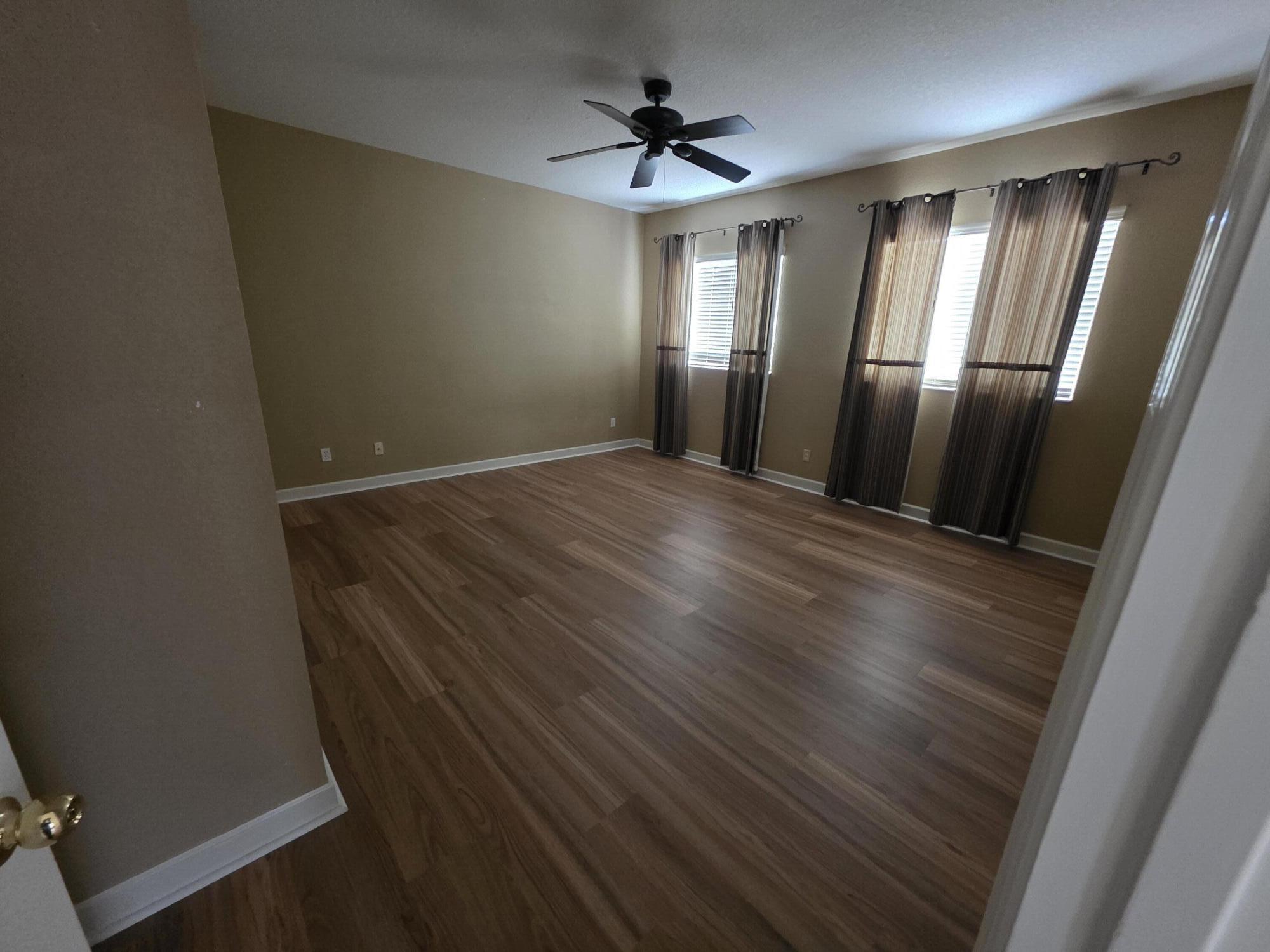 323 Northwest Sheffield Circle Port St. Lucie, FL 34983 - Photo 23 of 31 wooden floor in an empty room with a window
