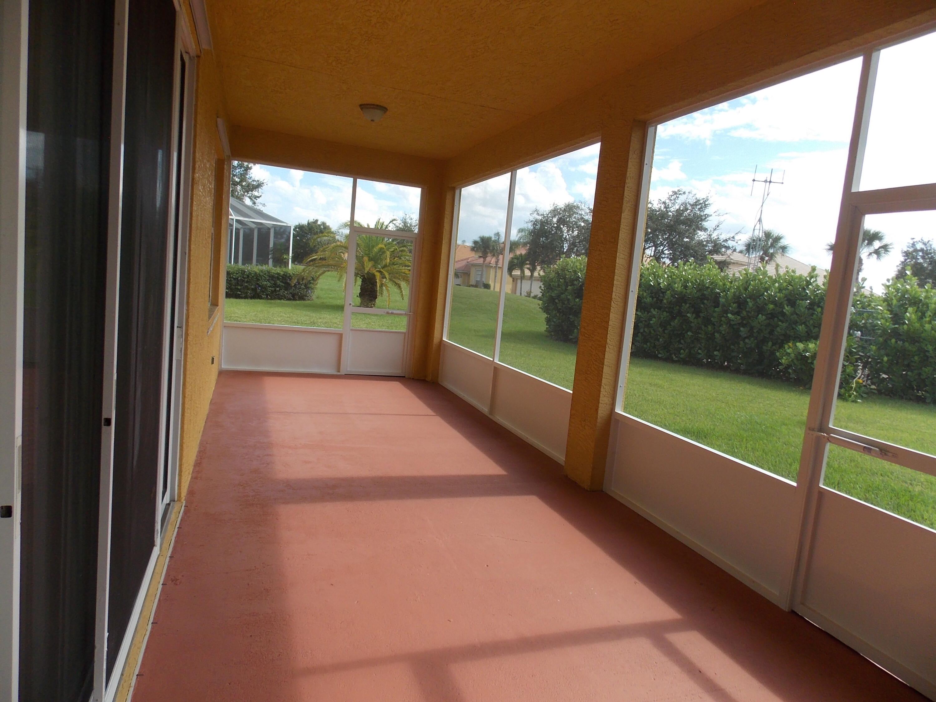 323 Northwest Sheffield Circle Port St. Lucie, FL 34983 - Photo 25 of 31 a view of a porch with wooden floor and a yard