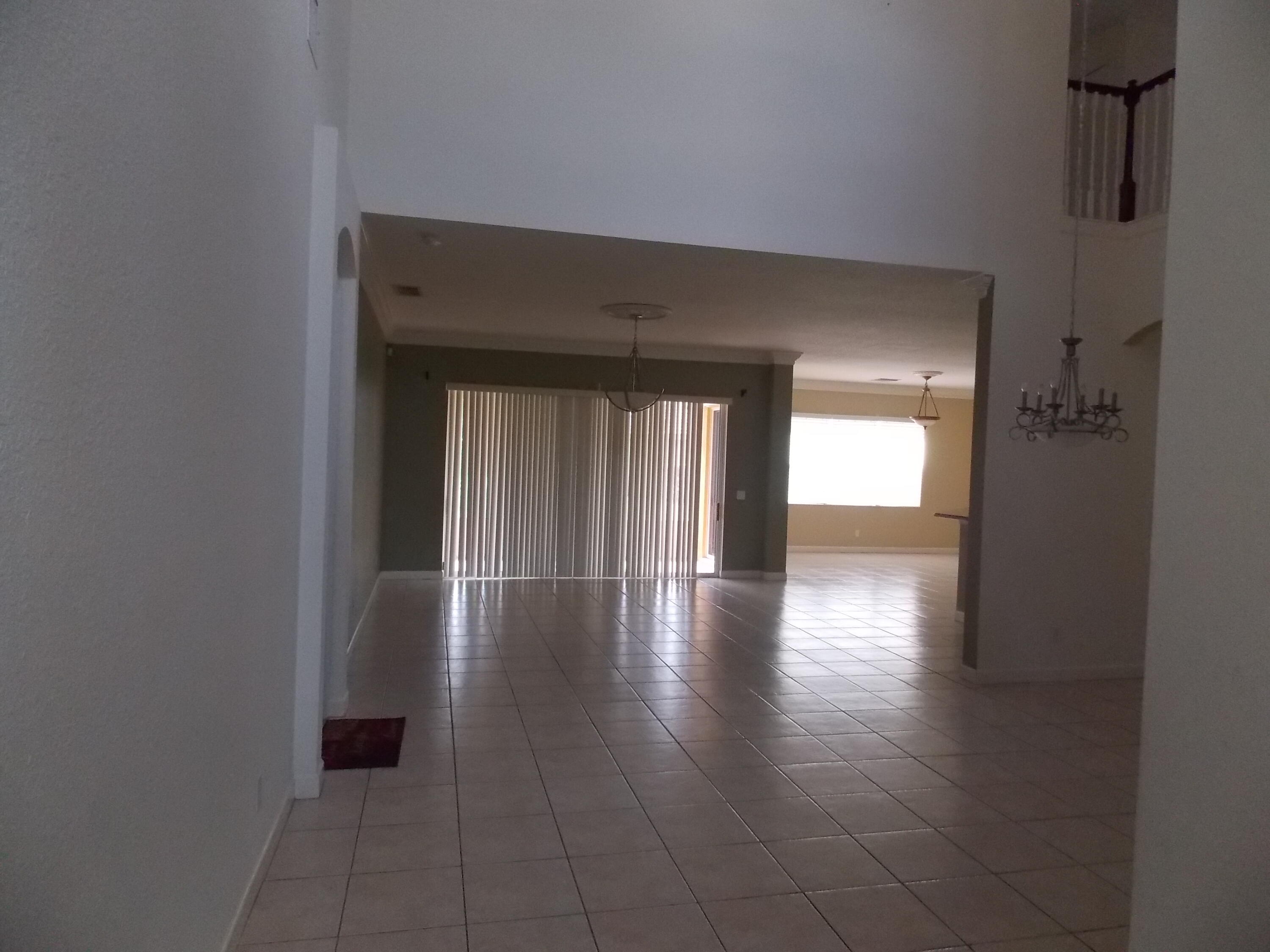 323 Northwest Sheffield Circle Port St. Lucie, FL 34983 - Photo 3 of 31 a view of empty room with wooden floor and fan