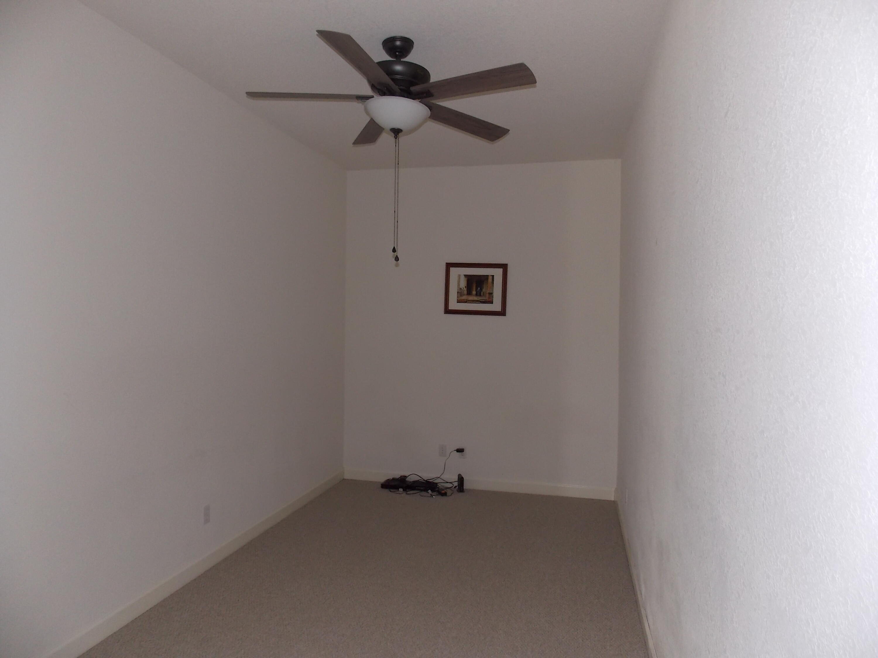 323 Northwest Sheffield Circle Port St. Lucie, FL 34983 - Photo 5 of 31 an empty room with a ceiling fan and a window
