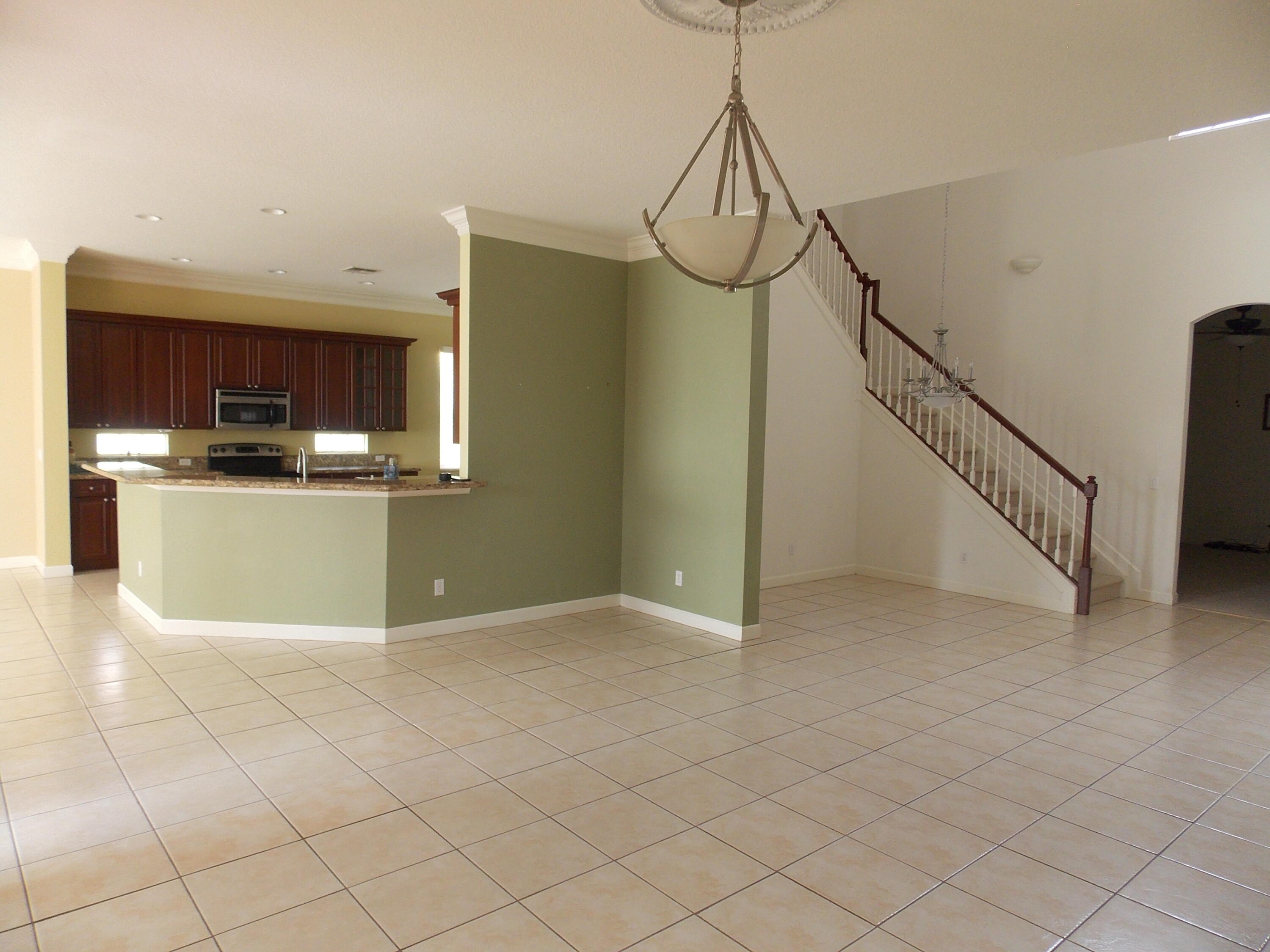 323 Northwest Sheffield Circle Port St. Lucie, FL 34983 - Photo 6 of 31 a view of a kitchen with a sink and dishwasher a refrigerator with white cabinets