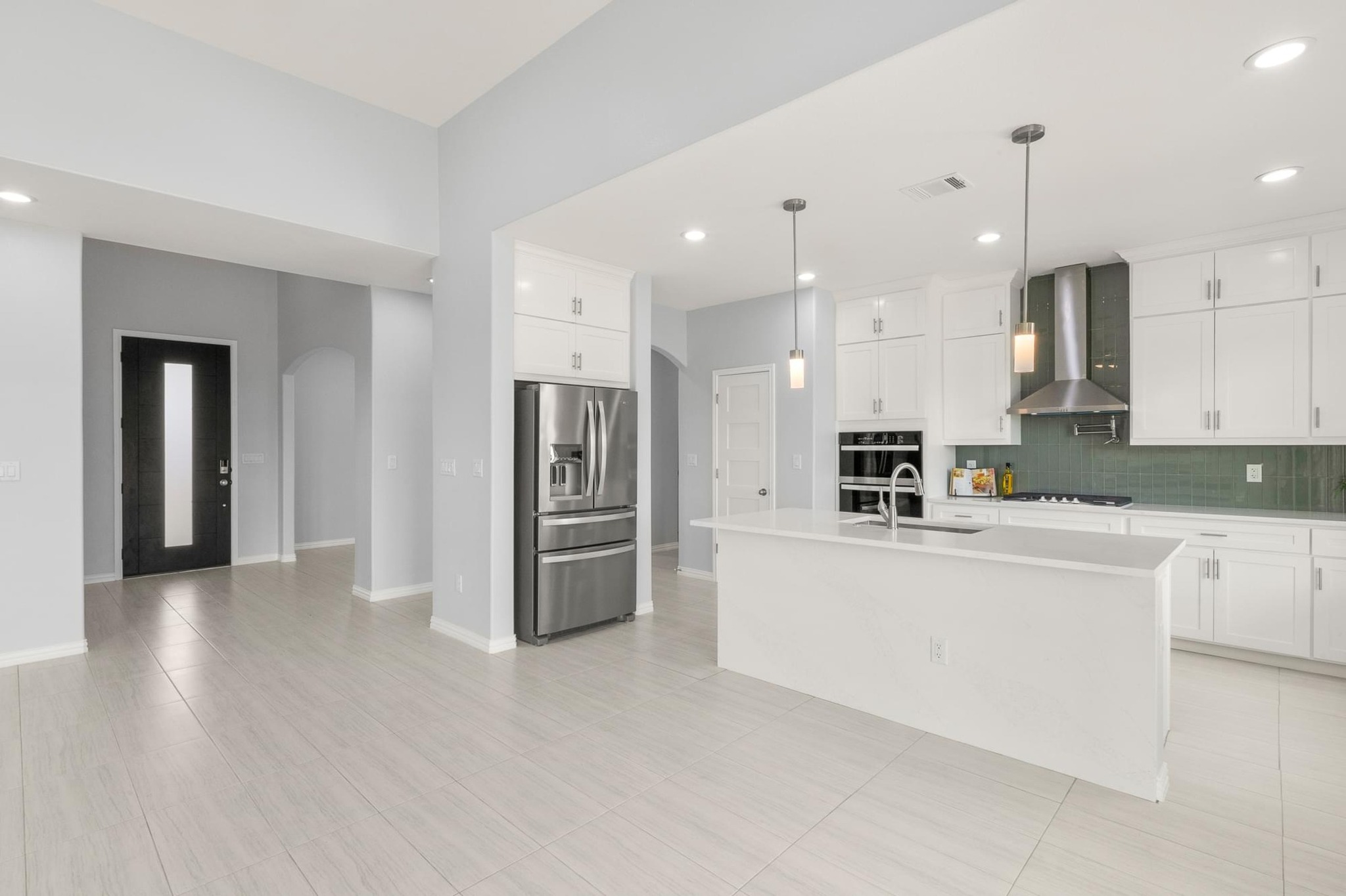 1136 County Road 484 Elgin, TX 78621 - Photo 11 of 37 Kitchen with black appliances, an island with sink, arched walkways, decorative light fixtures, and recessed lighting