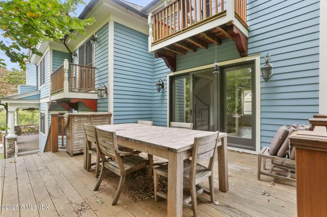 a view of a patio with table and chairs with wooden floor and fence