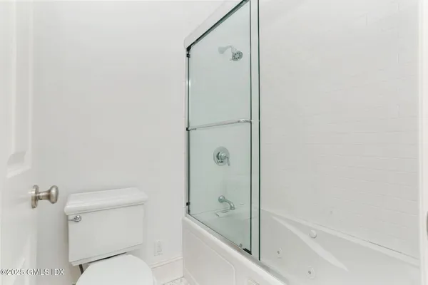 a bathroom with a granite countertop bathtub shower and toilet