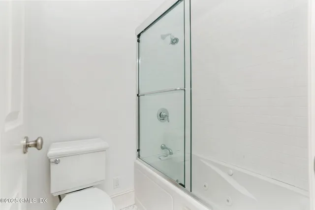 a bathroom with a granite countertop bathtub shower and toilet