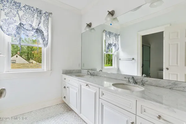 a bathroom with a granite countertop sink mirror and window
