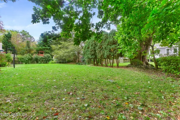 a view of green field with trees in the background
