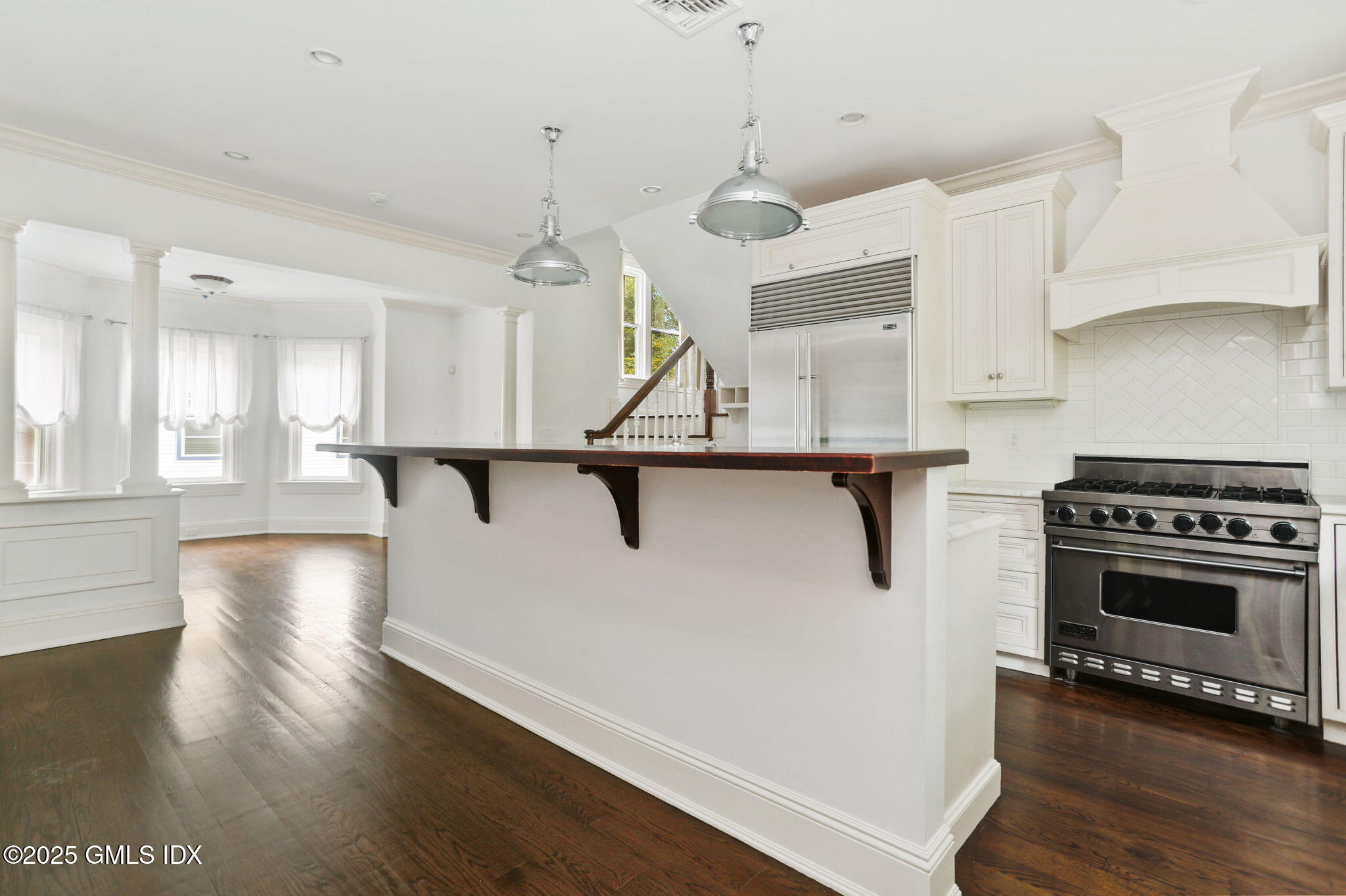 11 Harding Road Old Greenwich, CT 06870 - Photo 9 of 31 a kitchen with stainless steel appliances granite countertop a refrigerator a stove a sink dishwasher and a dining table with wooden floor