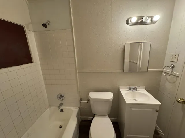 a bathroom with a sink and mirror with toilet