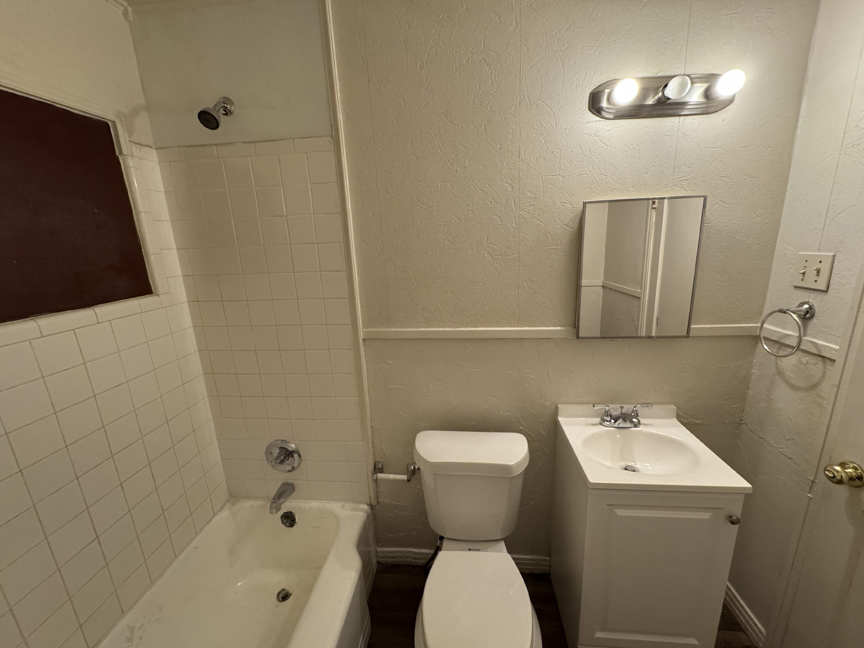 2119 32nd Street Lubbock, TX 79411 - Photo 7 of 9 a bathroom with a sink and mirror with toilet