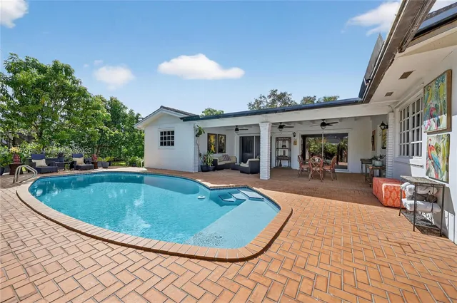a view of a house with swimming pool and sitting area