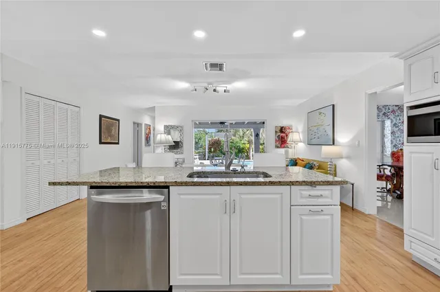 a kitchen with granite countertop a sink and cabinets