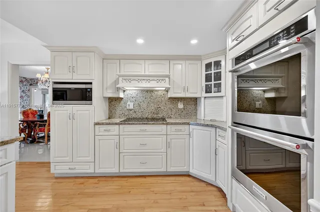 a kitchen with stainless steel appliances granite countertop a stove microwave and cabinets