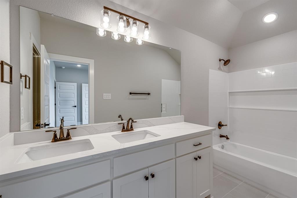 912 Cooksey Court, Unit B Grandview, TX 76050 - Photo 16 of 30 a bathroom with a sink a large mirror and a bathtub