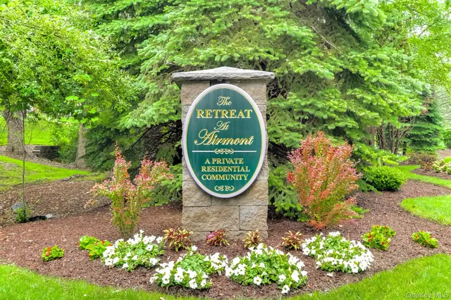 a sign that is sitting in front of a tree