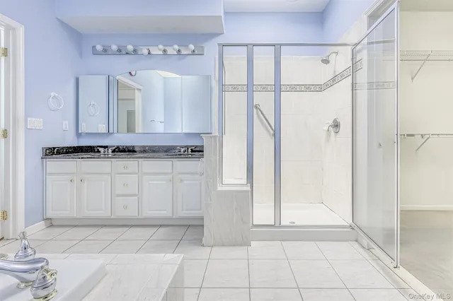 a bathroom with a granite countertop sink a mirror and a shower