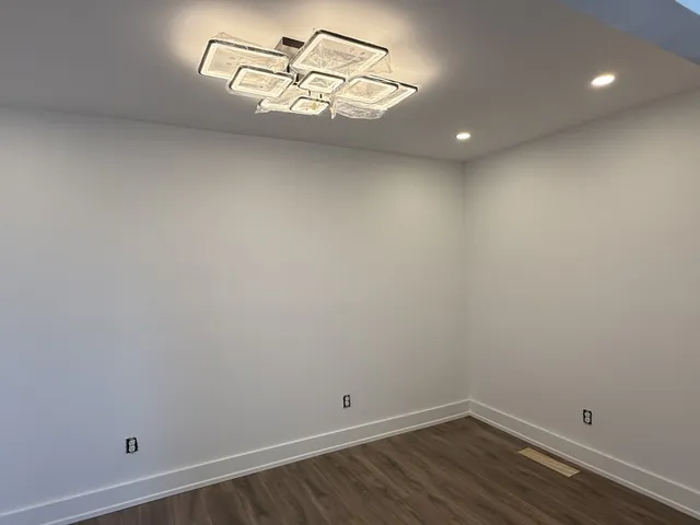 a view of a room with wooden floor and white walls