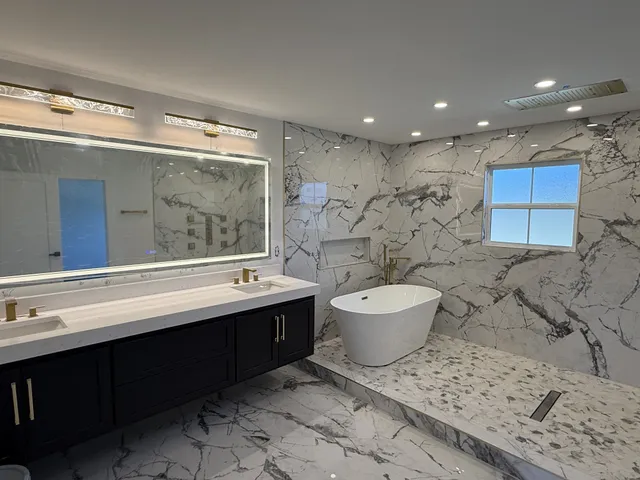 a bathroom with a bathtub sink mirror and toilet