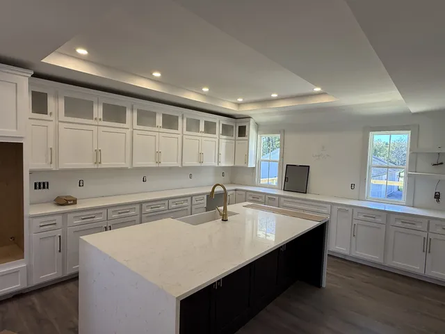 a kitchen with sink cabinets and wooden floor
