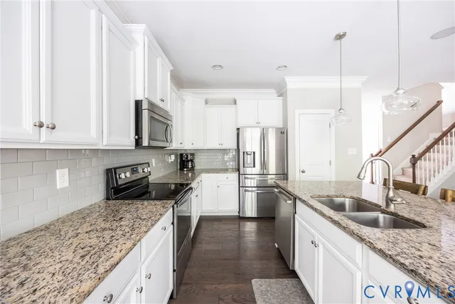a kitchen with kitchen island granite countertop white cabinets and stainless steel appliances