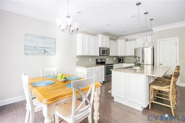 a kitchen with stainless steel appliances granite countertop a kitchen island a stove and a wooden floors