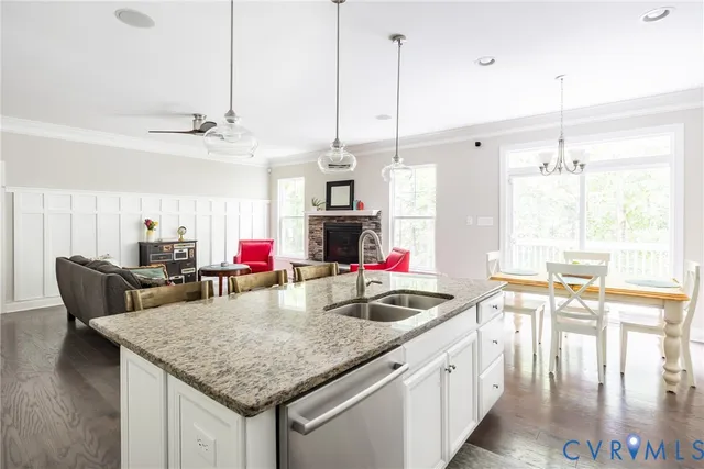 a living room with stainless steel appliances kitchen island a dining table and chairs with wooden floor