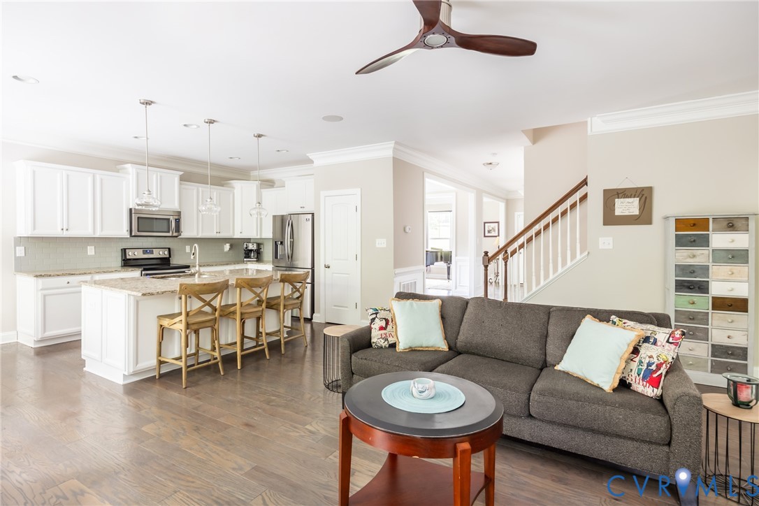 15206 Blackrail Road Chesterfield, VA 23832 - Photo 18 of 50 a living room with stainless steel appliances kitchen island a dining table and chairs with wooden floor