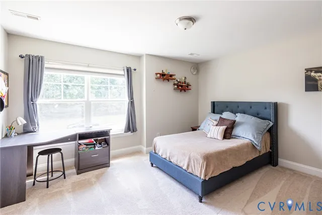 a bedroom with a bed chandelier and couch