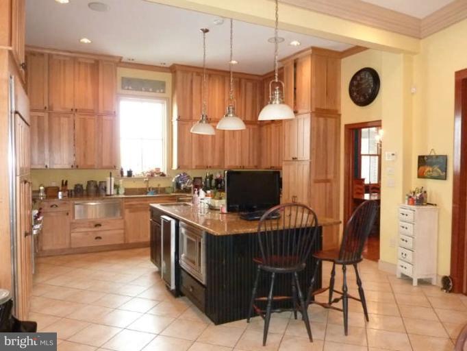 1003 Hiatt Road Winchester, VA 22603 - Photo 12 of 28 a open kitchen with stainless steel appliances granite countertop a stove top oven a sink a dining table and chairs with the cabinets