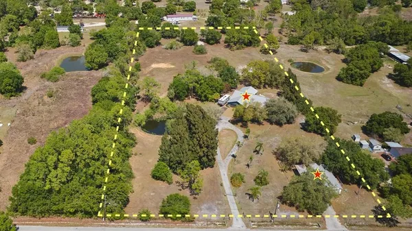 an aerial view of a house with a yard and lake view