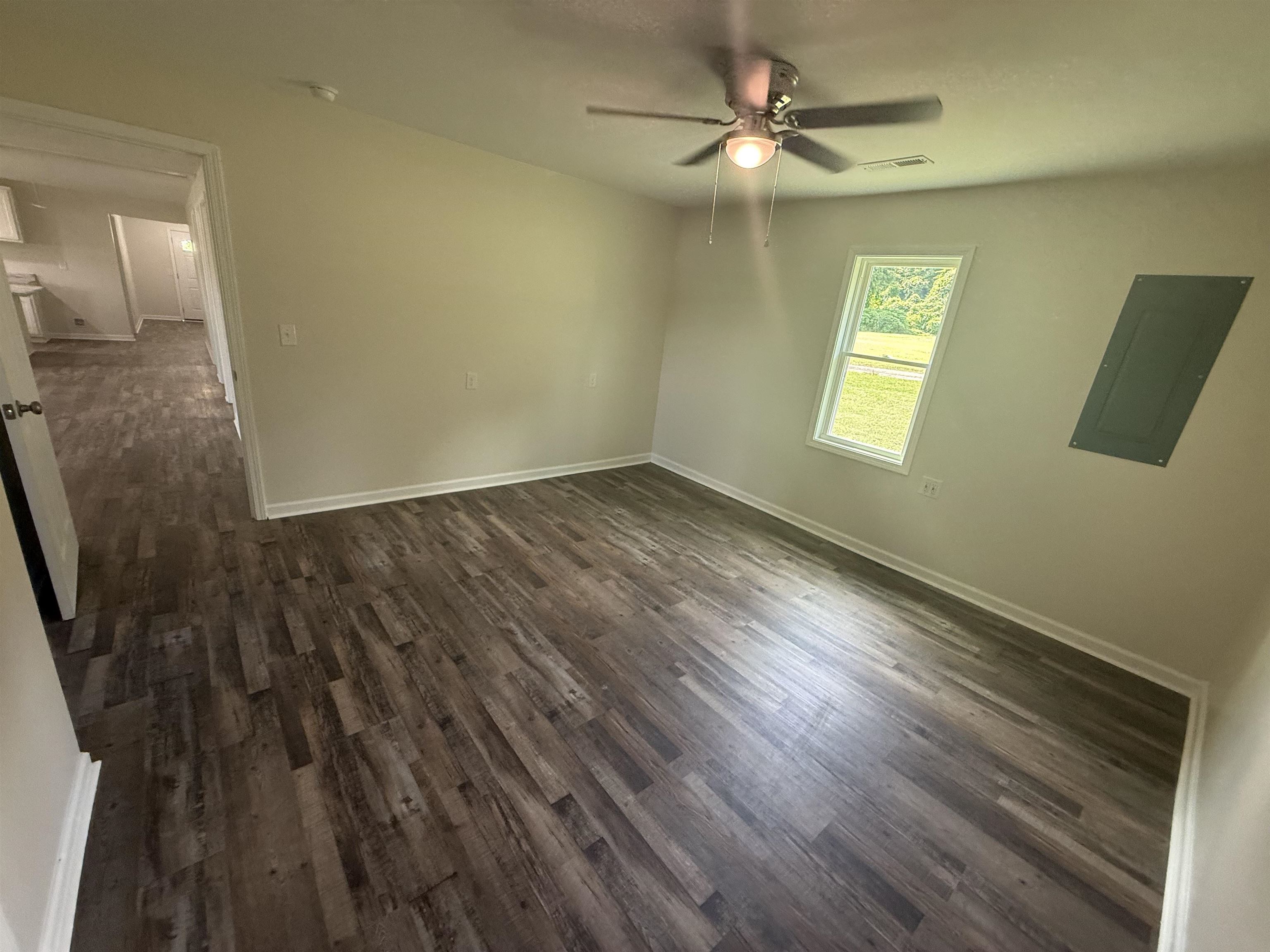170 Leapwood Road Enville, TN 38332 - Photo 13 of 33 Spacious room featuring wood-finish flooring, a ceiling fan with integrated lighting, and a window with white trim