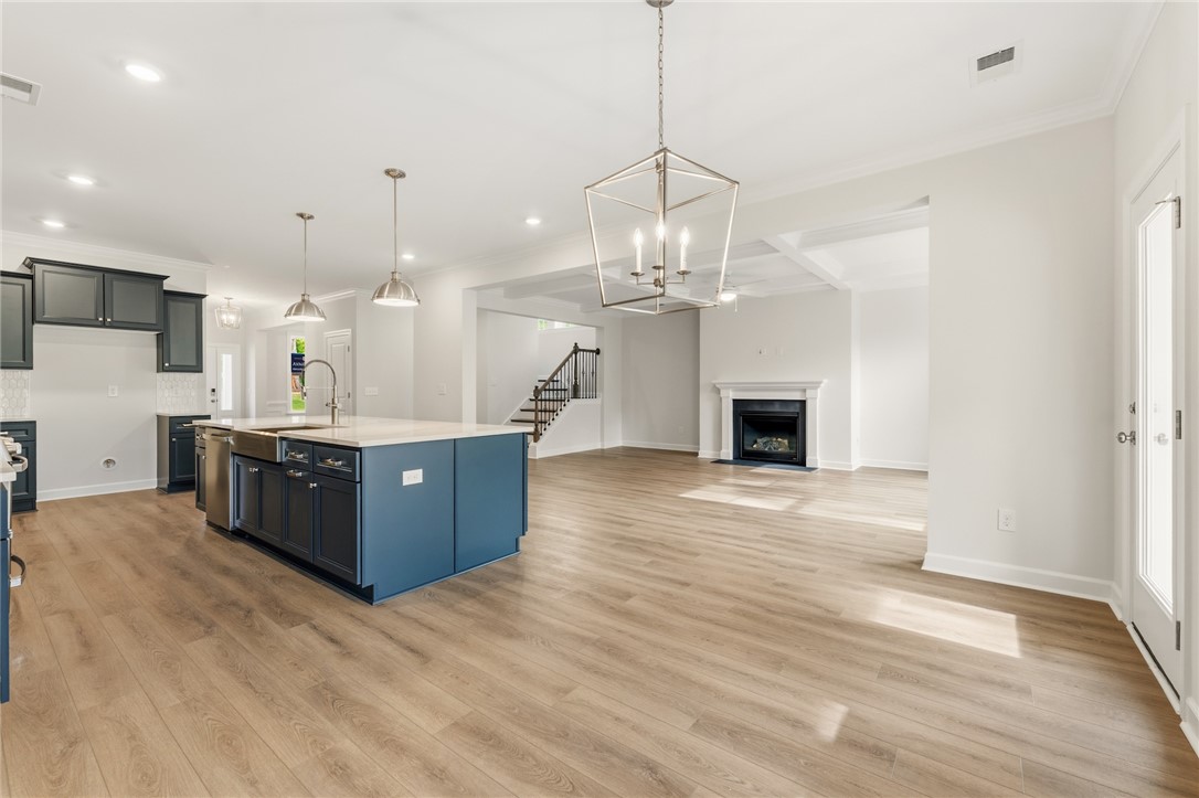 1108 Manse Jolly Road Anderson, SC 29621 - Photo 13 of 45 This expansive open concept living space features a modern kitchen, inviting fireplace, and rich hardwood flooring.