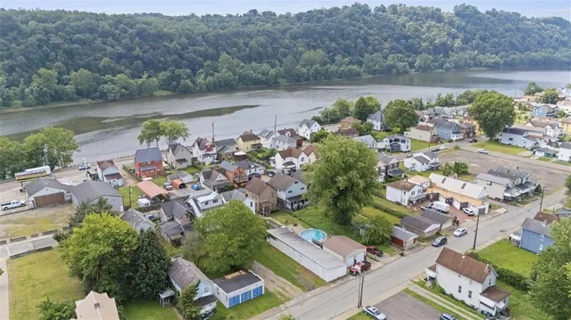 an aerial view of a house with garden space and lake view