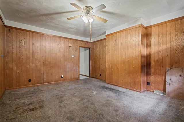 an empty room with a chandelier fan