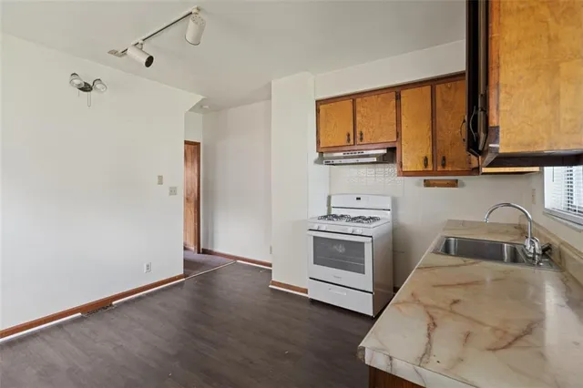 a kitchen with a stove a sink and a window