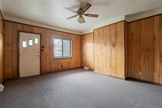 an empty room with windows and fan