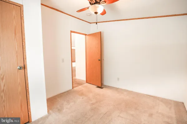 a view of a room with a ceiling fan and a window