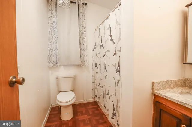 a bathroom with a granite countertop shower and a toilet